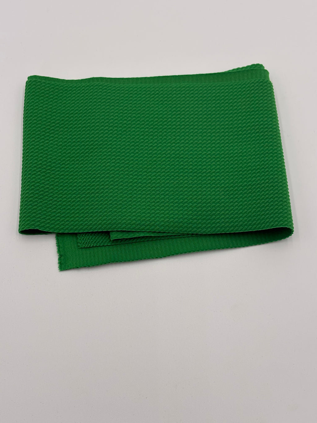 Folded lime green fabric on a white background