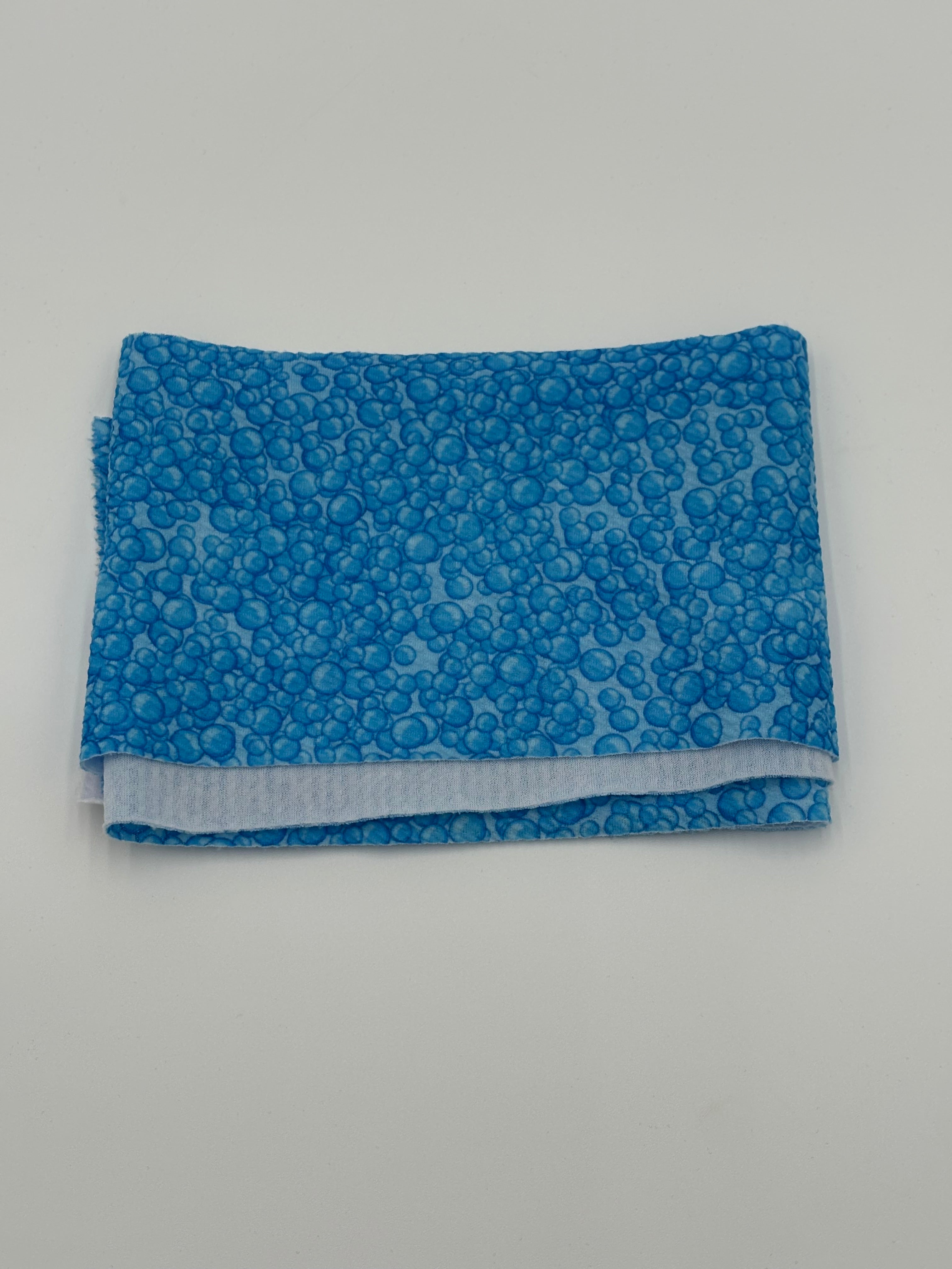 Folded fabric with blue bubbles pattern on a white background