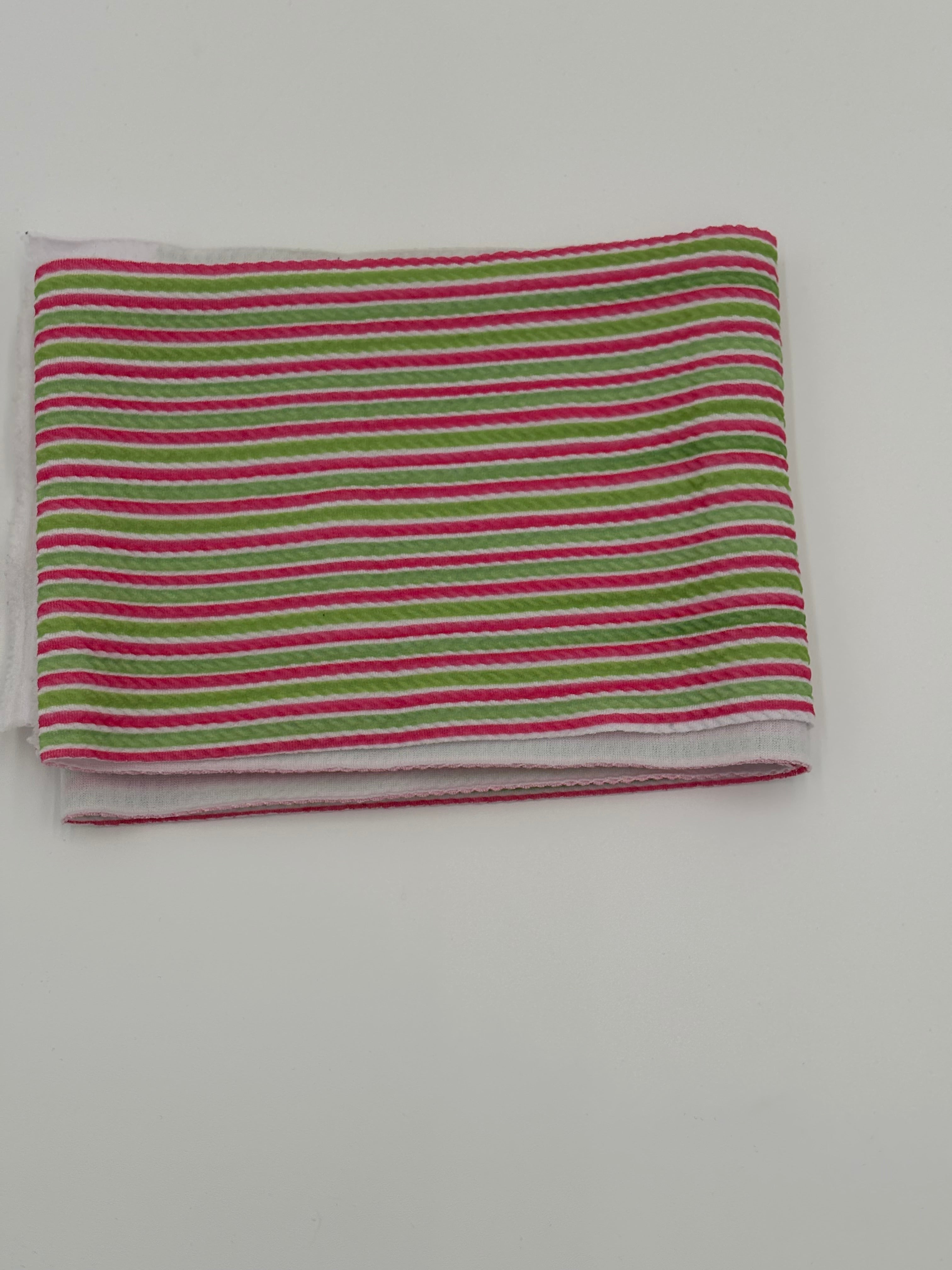Striped fabric with green and pink stripes on a white background