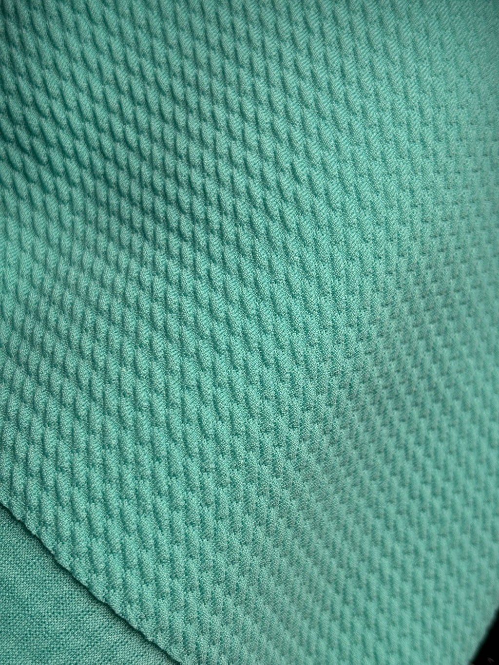 Close-up of aquamarine fabric with a textured pattern