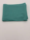 Folded aquamarine fabric on a white background