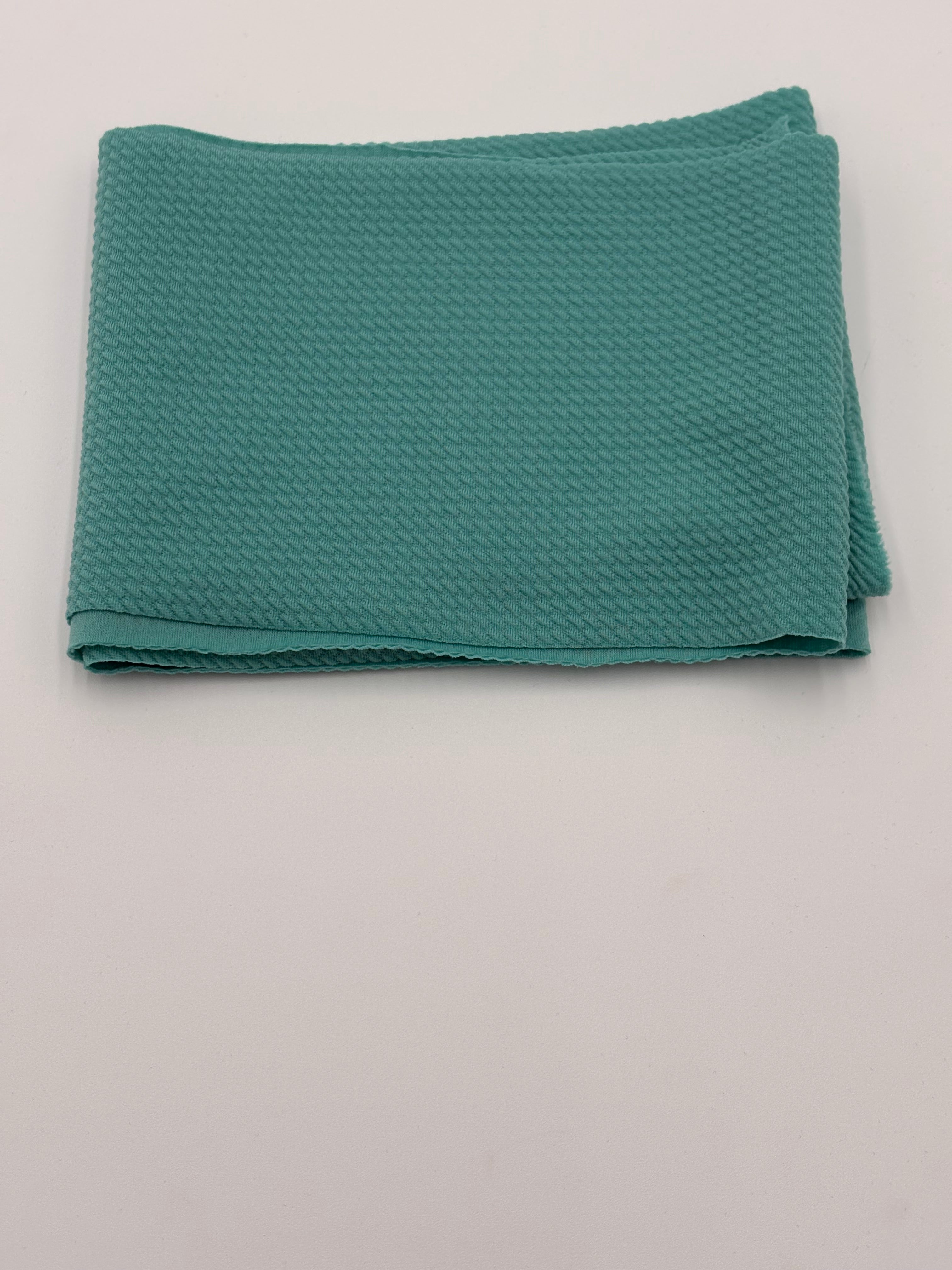 Folded aquamarine fabric on a white background