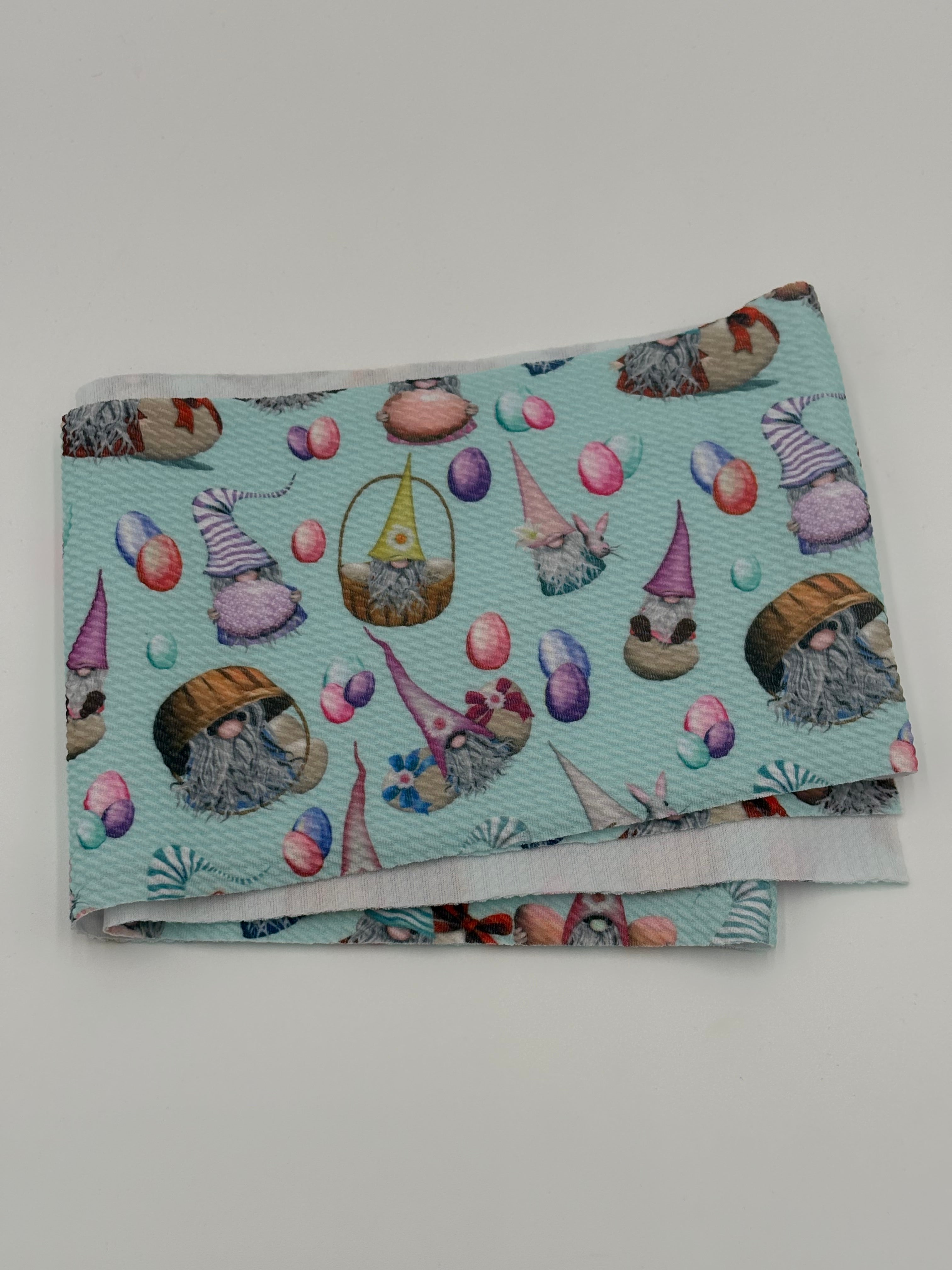Folded fabric with Easter gnomes  pattern on a white background
