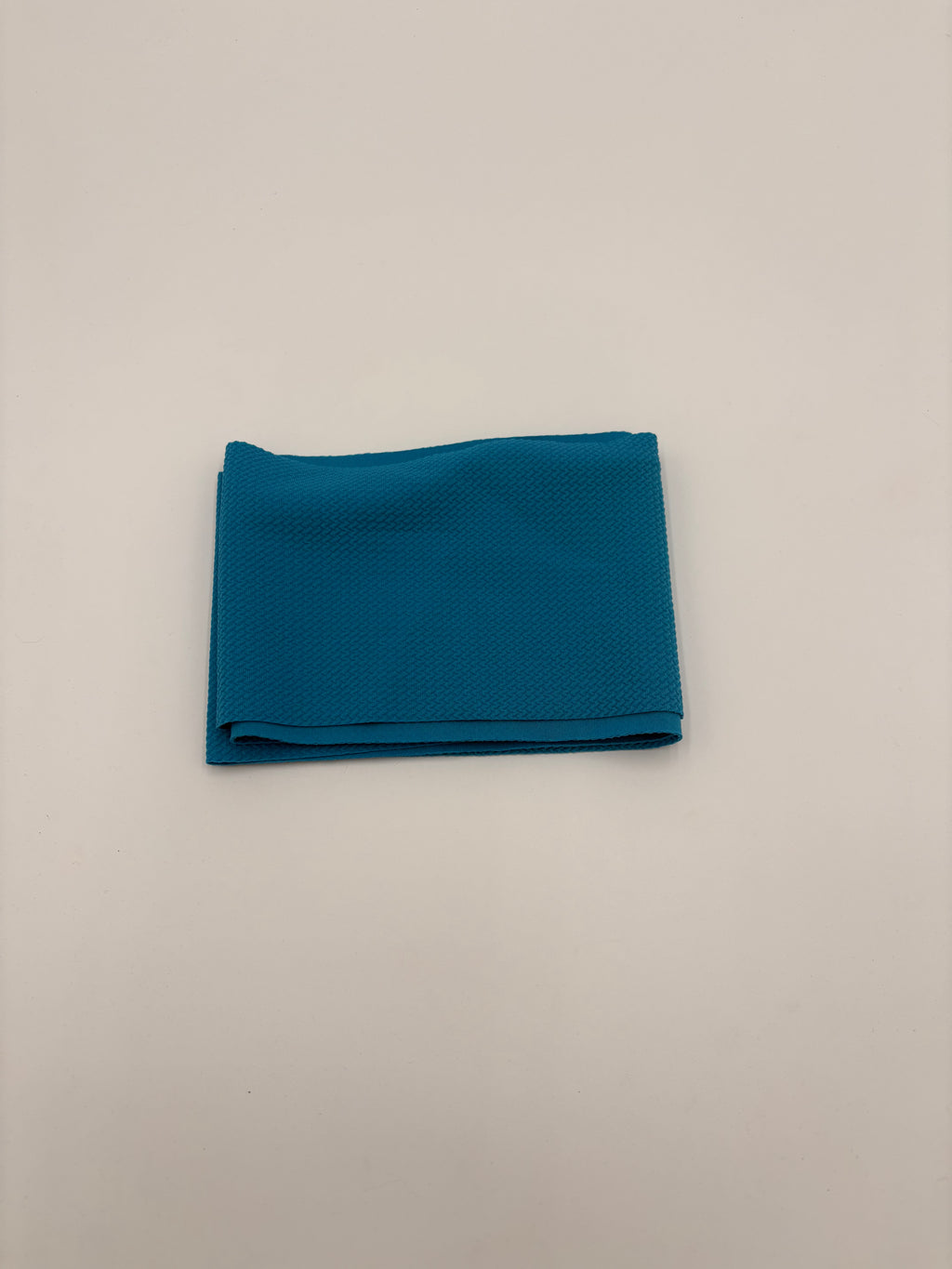 Folded aqua blue fabric on a white background