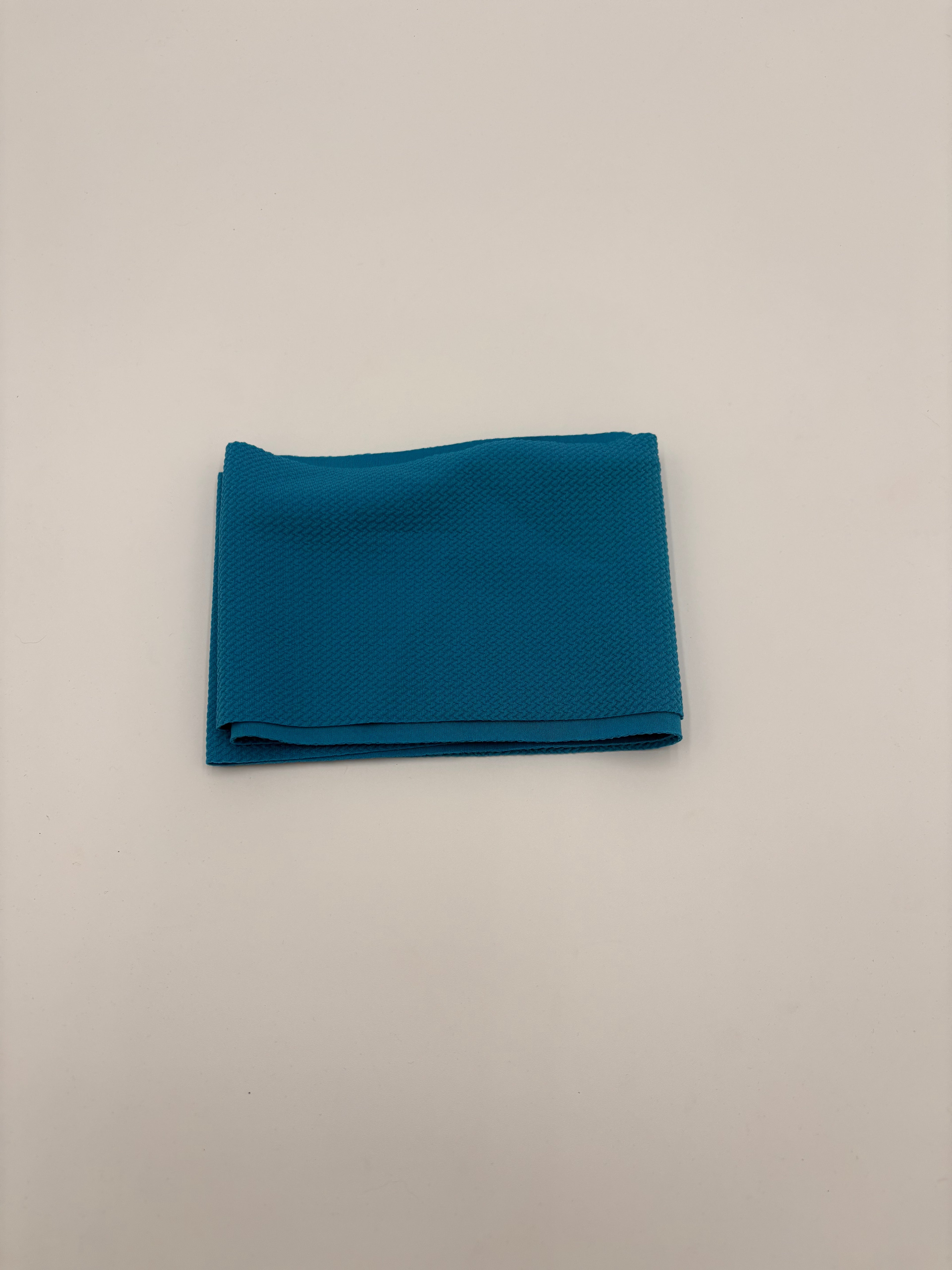 Folded aqua blue fabric on a white background