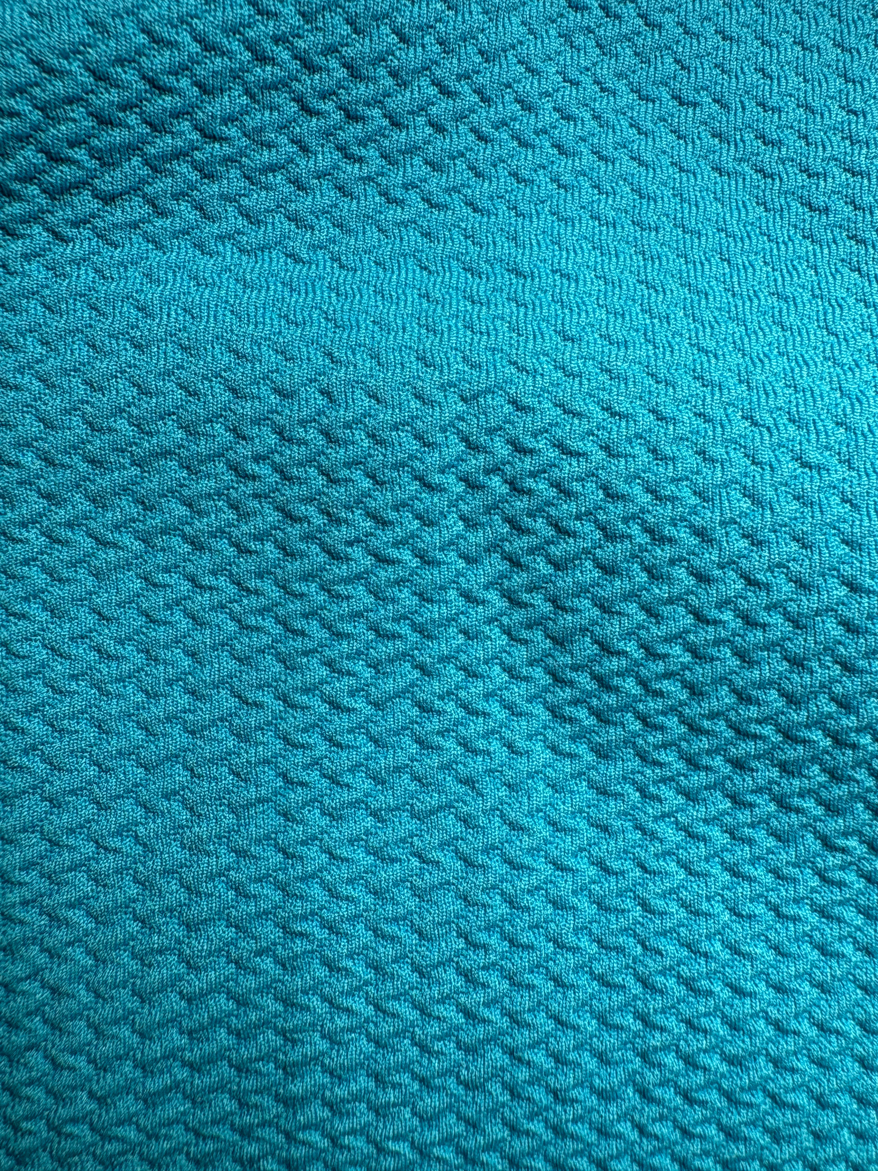 Close-up of aqua blue fabric with a textured pattern