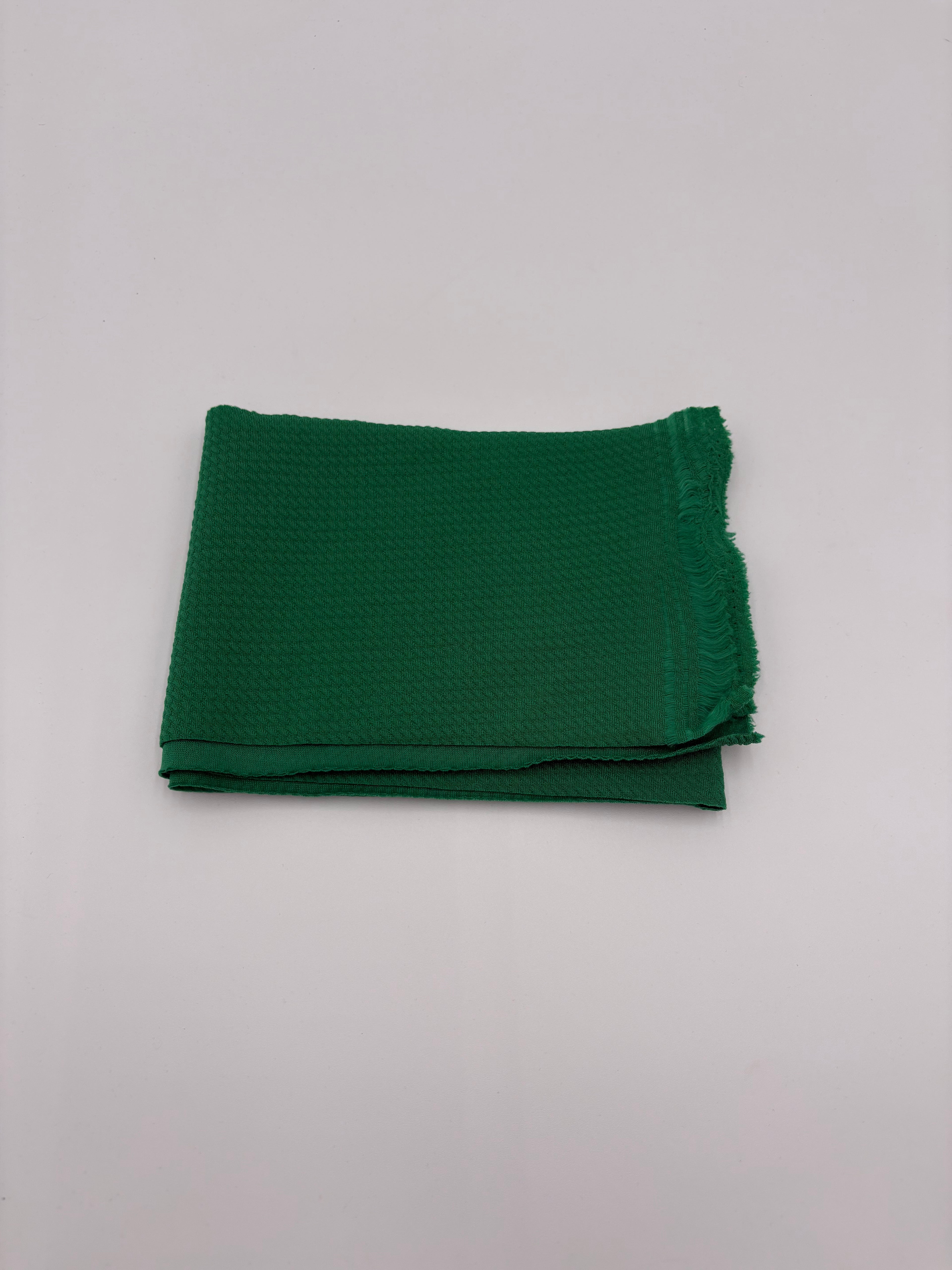 Folded green fabric on a white background