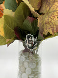 Bouquet of flowers with a man with scissors as hands hugging a girl badge holder in a clear vase on a white background