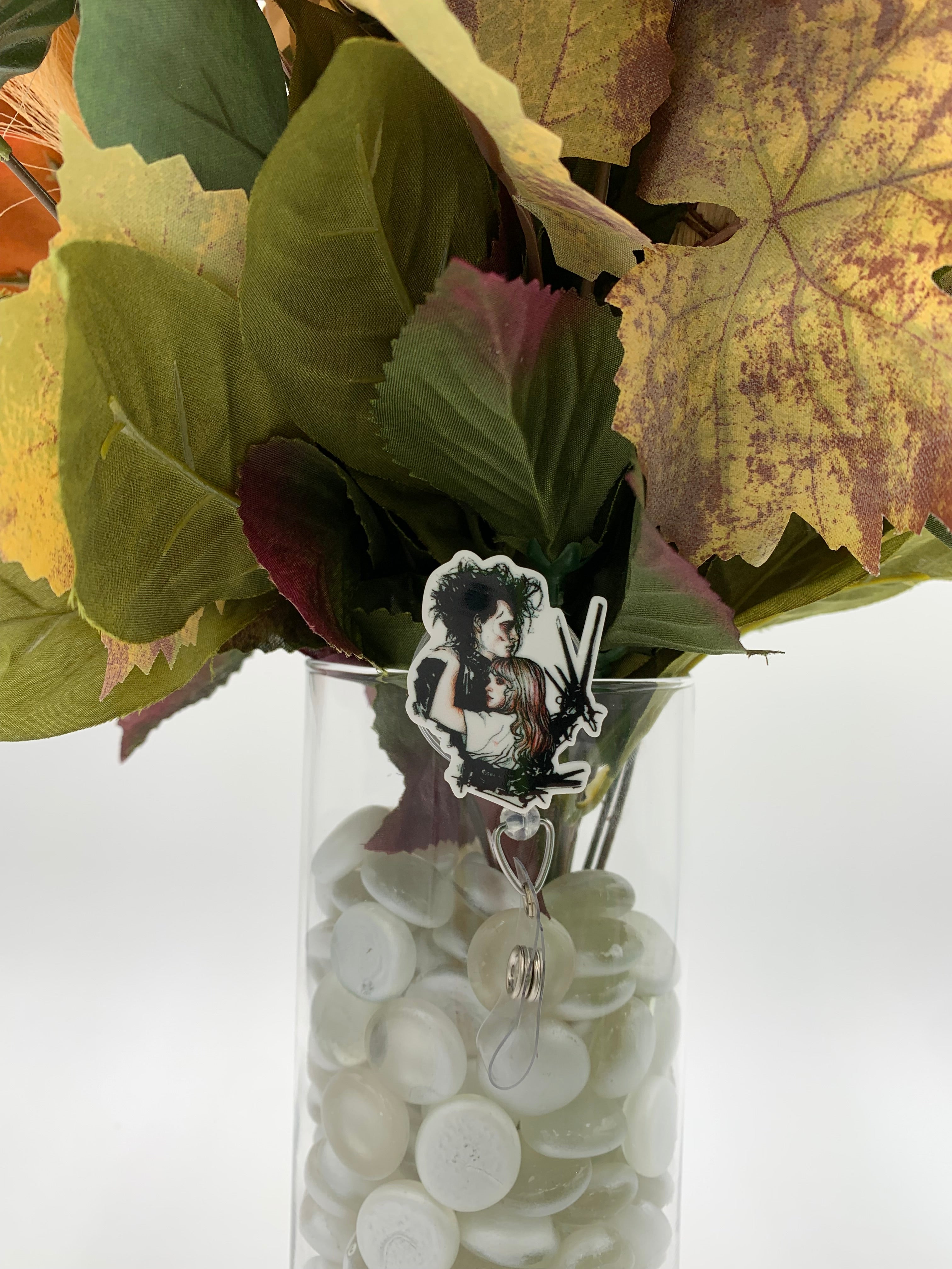 Bouquet of flowers with a man with scissors as hands hugging a girl badge holder in a clear vase on a white background