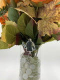 Bouquet of flowers with a man holding a machete badge holder in a clear vase on a white background