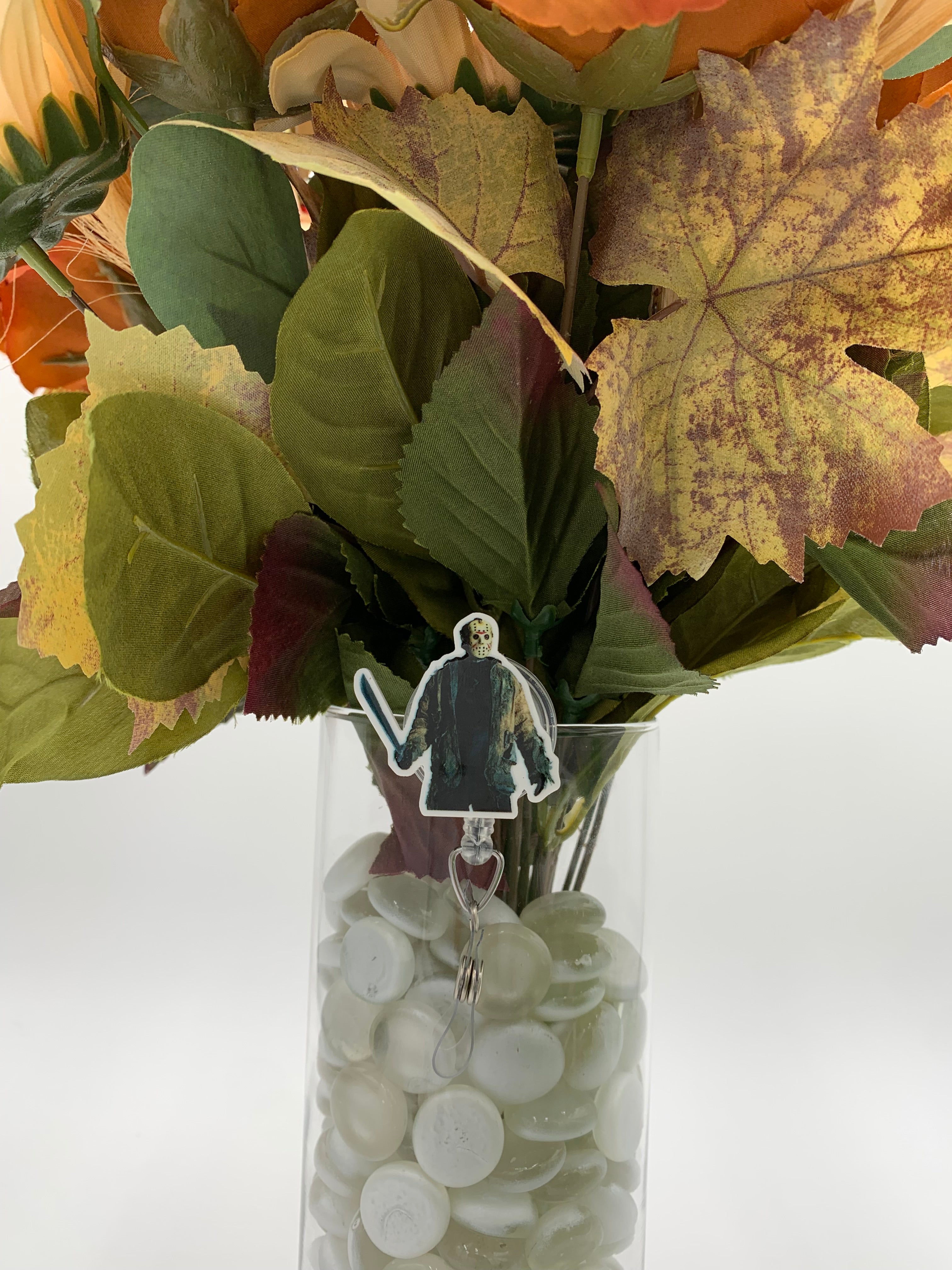Bouquet of flowers with a man holding a machete badge holder in a clear vase on a white background