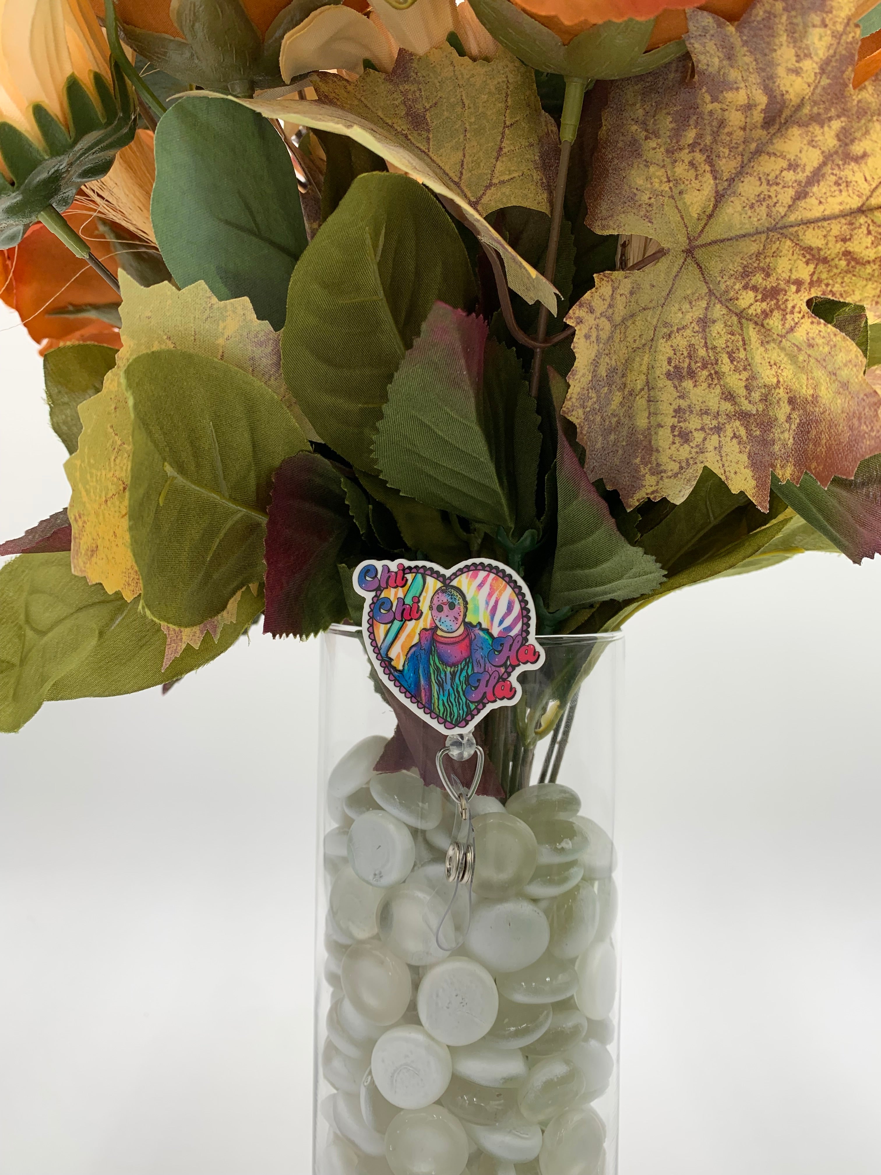 Bouquet of flowers with a multicolored heart with a man holding a machete inside badge holder in a clear vase on a white background
