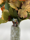 Bouquet of flowers with a man holding a machete badge holder in a clear vase on a white background