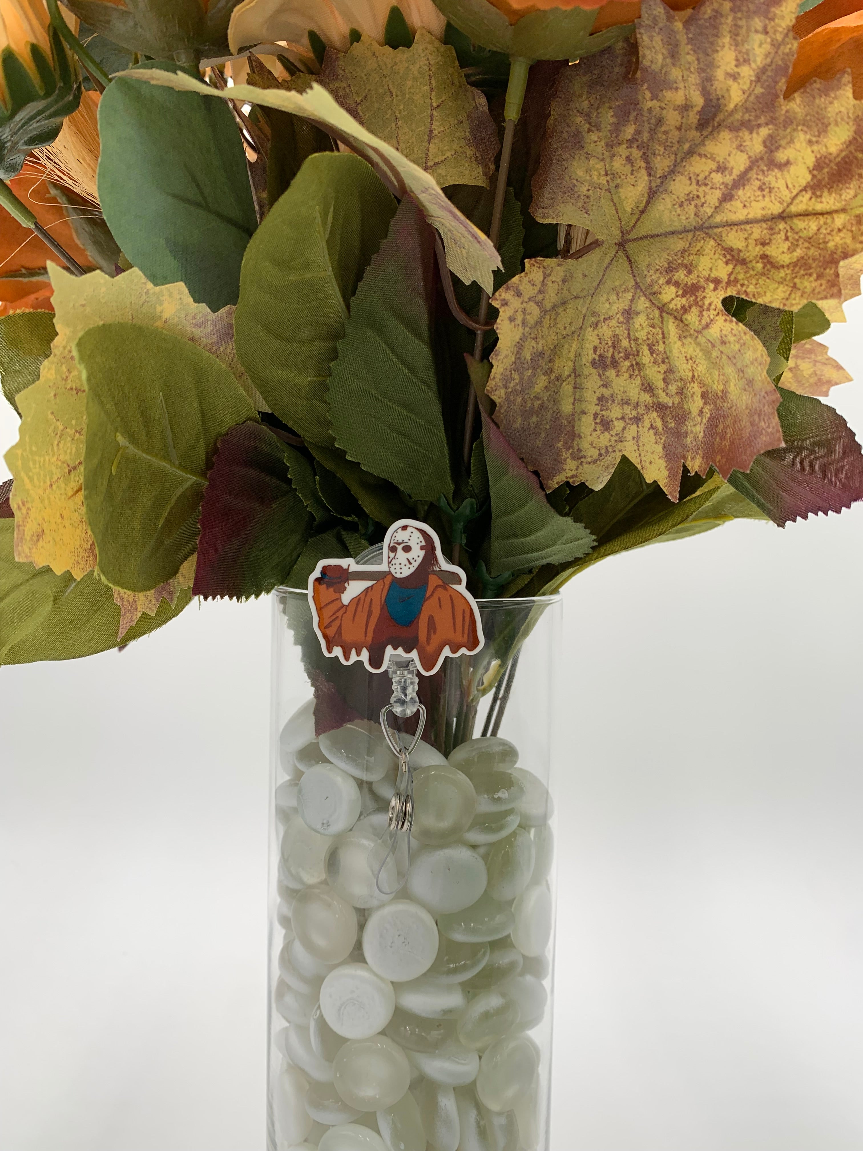 Bouquet of flowers with a man with a white mask holding a machete badge holder in a clear vase on a white background