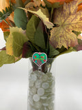 Bouquet of flowers with a brown gloved hand with the middle finger out with text "Freddy" badge holder in a clear vase on a white background