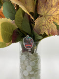 Bouquet of flowers with a hooded man with a white mask holding a knife with text "welcome to Woodsboro" badge holder in a clear vase on a white background