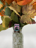 Bouquet of flowers with a hooded man with a white mask holding a knife with text "goosebumps" badge holder in a clear vase on a white background