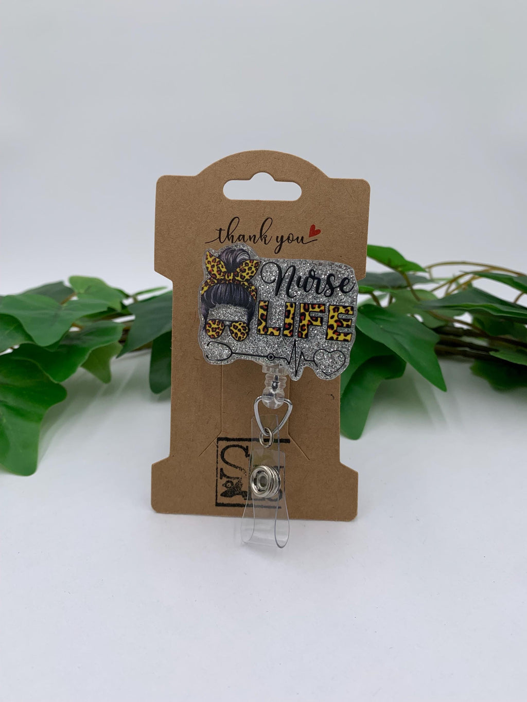 Badge holder with 'Nurse Life' text on a brown card with green leaves in the background