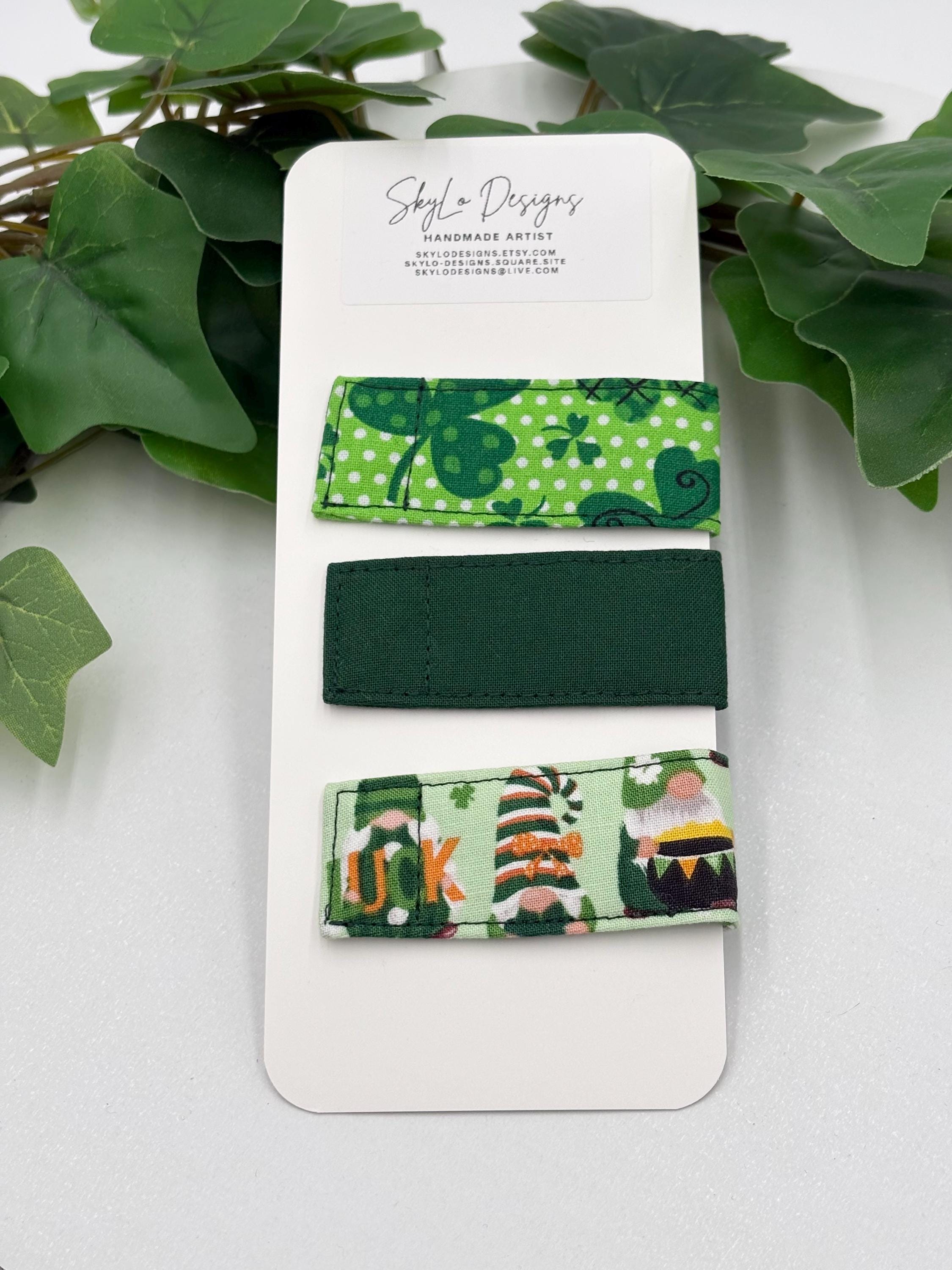 Set of green and white magnetic fabric bookmarks on a white card with leafy background