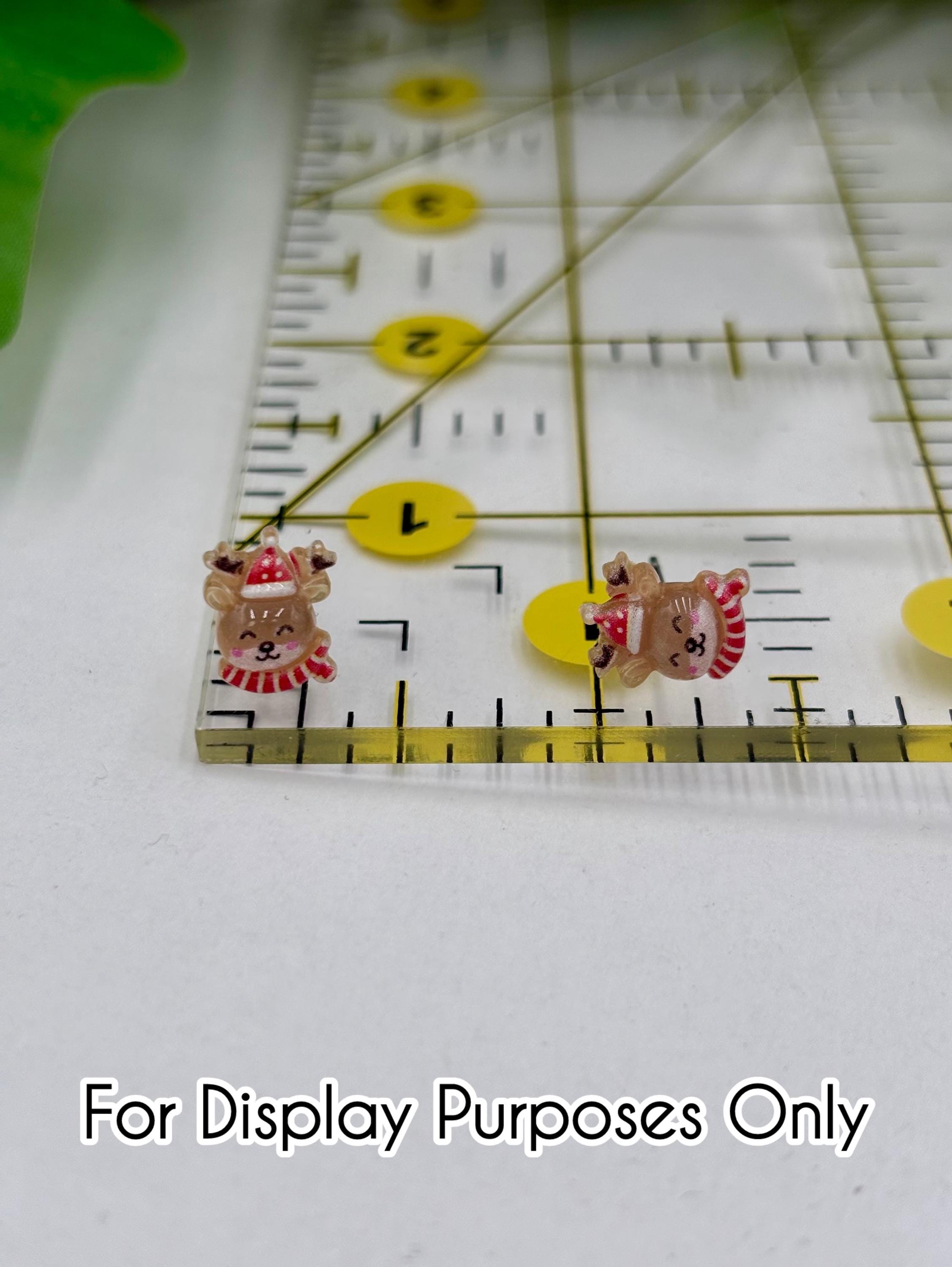 Two small reindeer-shaped earrings on a ruler with text 'For Display Purposes Only'.