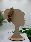 Leopard print scrunchie on a cardboard silhouette of a head with plants in the background