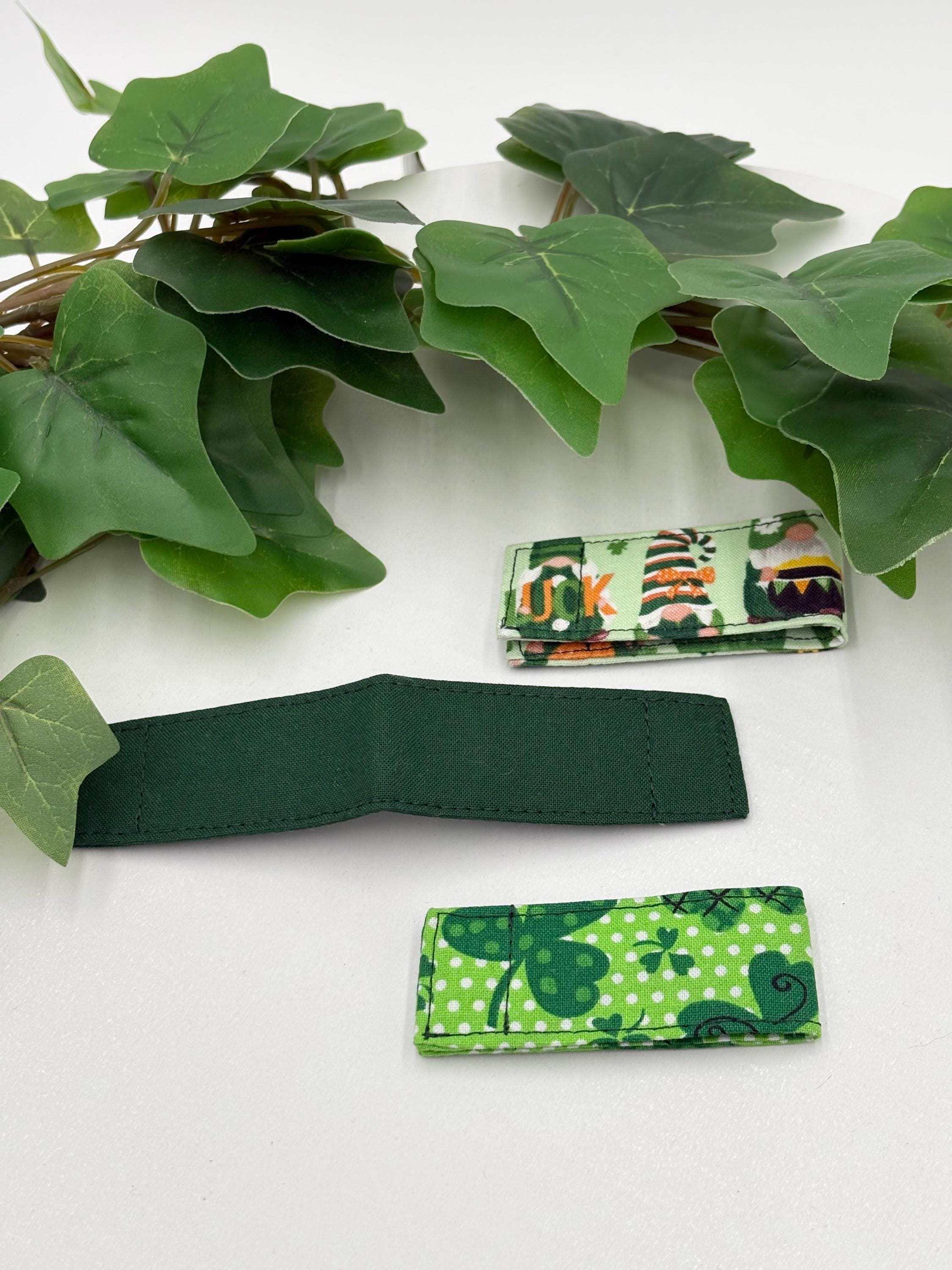 Three Green multi-pattern magnetic bookmarks on a white surface with ivy leaves.