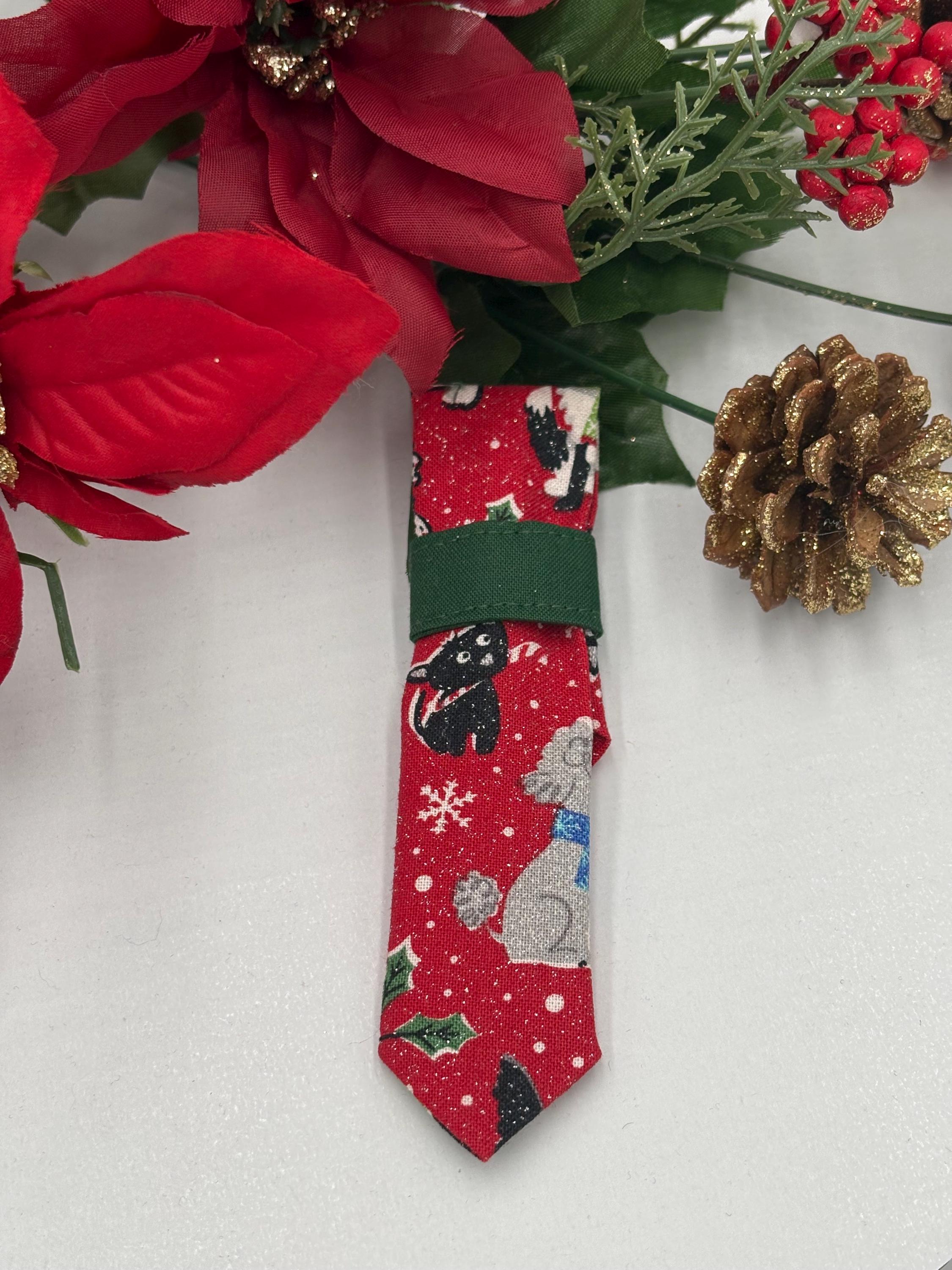 Red over the collar necktie with Christmas-themed dogs design on a white background with poinsettias and a pine cone.