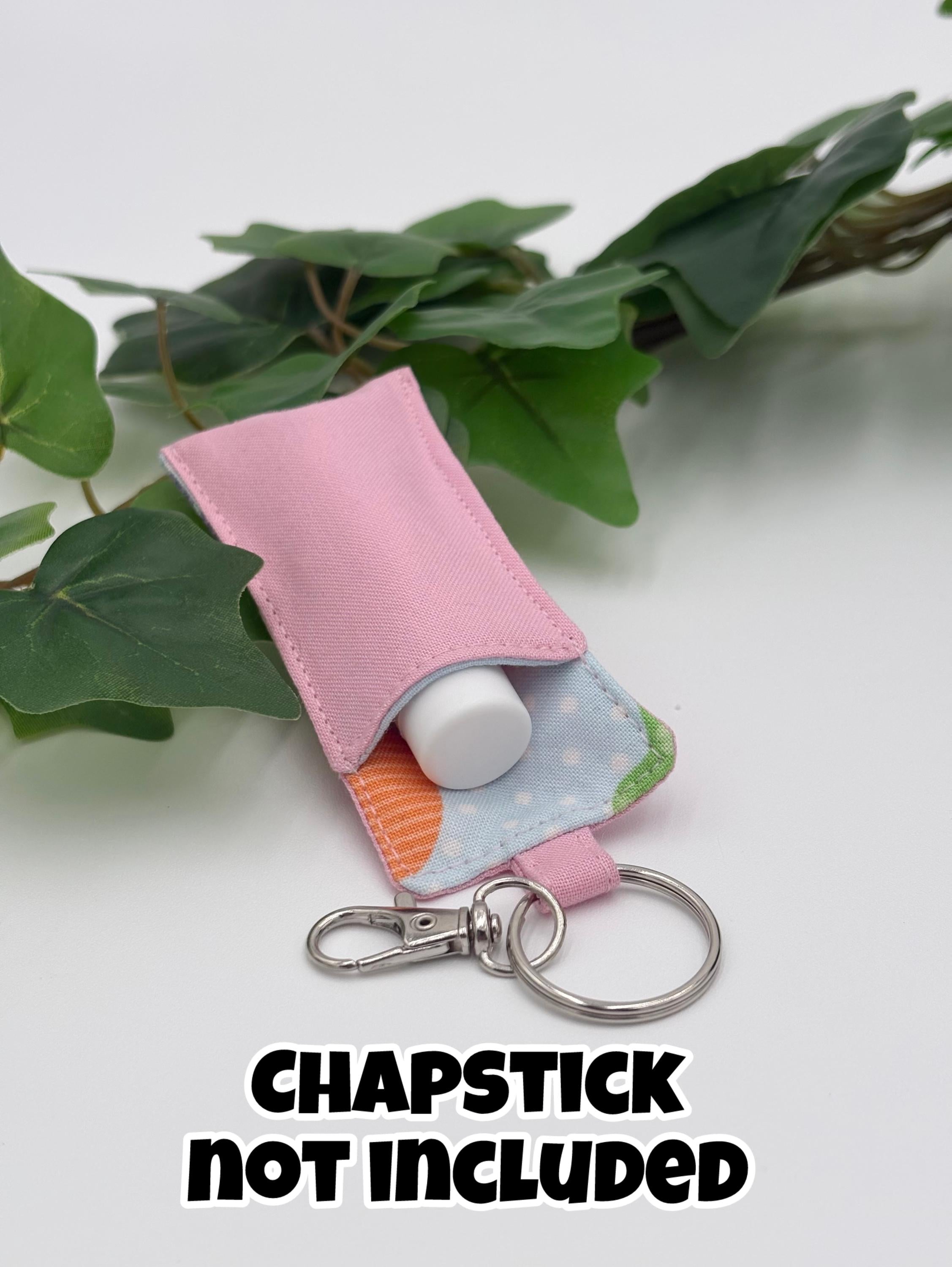 Pink easter themed chapstick holder on a white surface with green leaves in the background with text "chapstick not included"