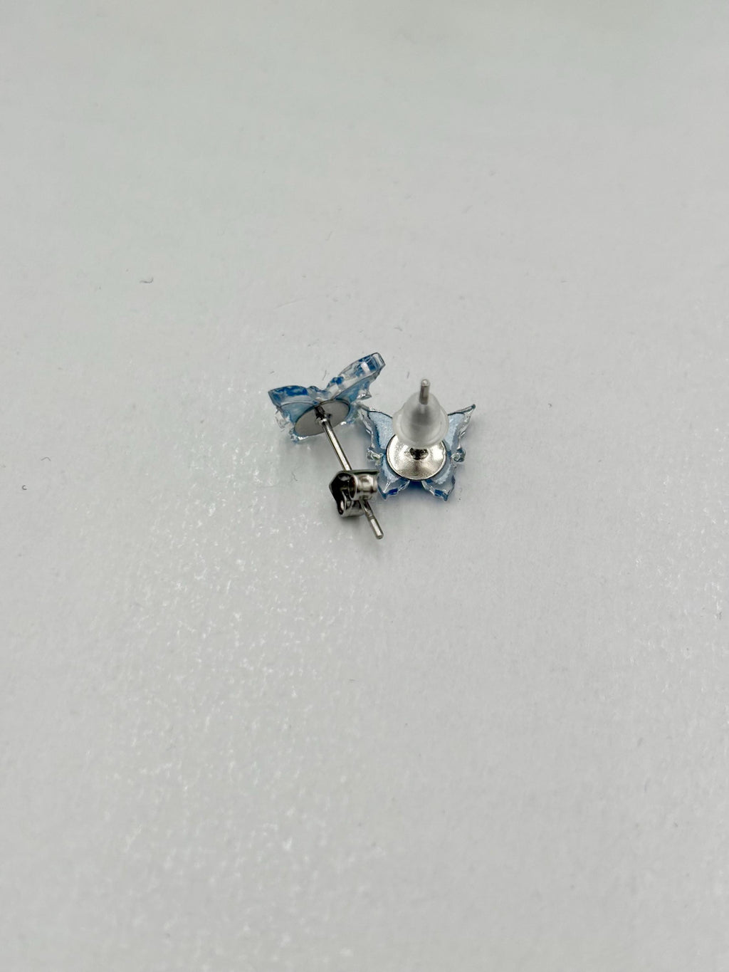Pair of blue butterfly earrings on a White background