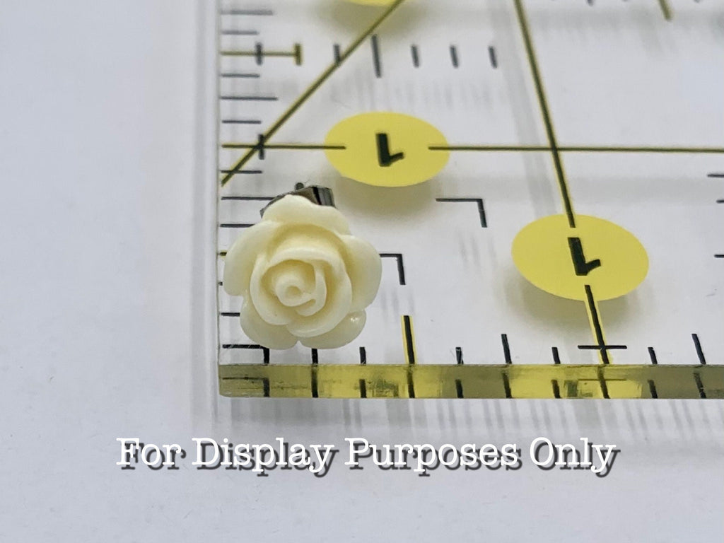 Butter Cream rose-shaped object on a ruler with measurement markings with text "for display purposes only"