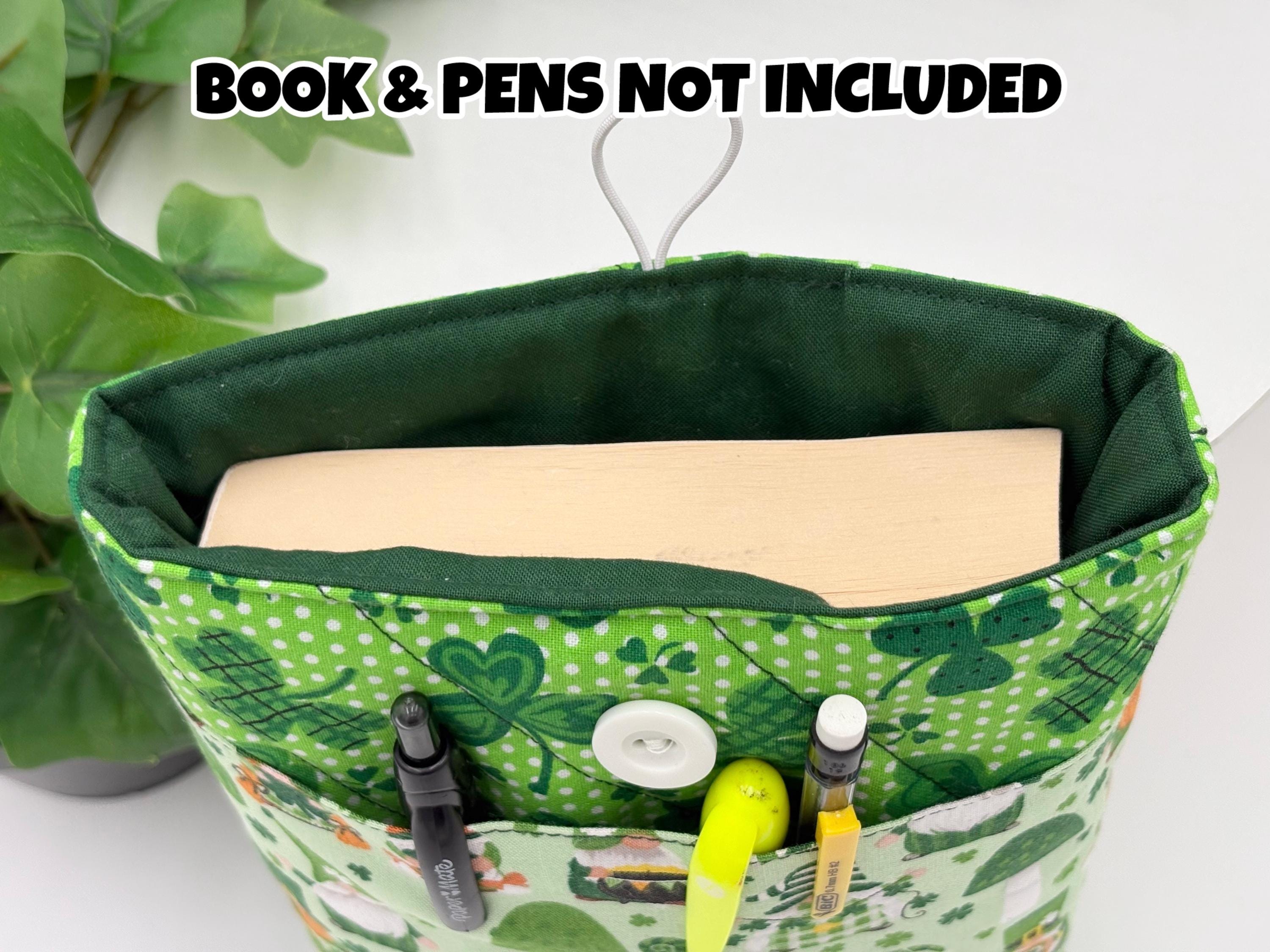 Close up of a Green saint Patrick’s day gnomes and clovers patterned book sleeve with pens and book inside it on a white surface and text “book and pens not included”