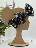 Black Headband with a decorative clocks and text "New Year" themed big bow on a mannequin head silhouette against a white background