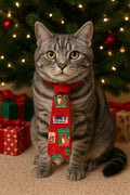 Cat wearing a red Christmas themed over the collar necktie with a decorated tree and presents in the background